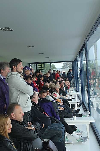 Spieler, Fans und Sponsoren im überdachten Bereich als der Regen kam...